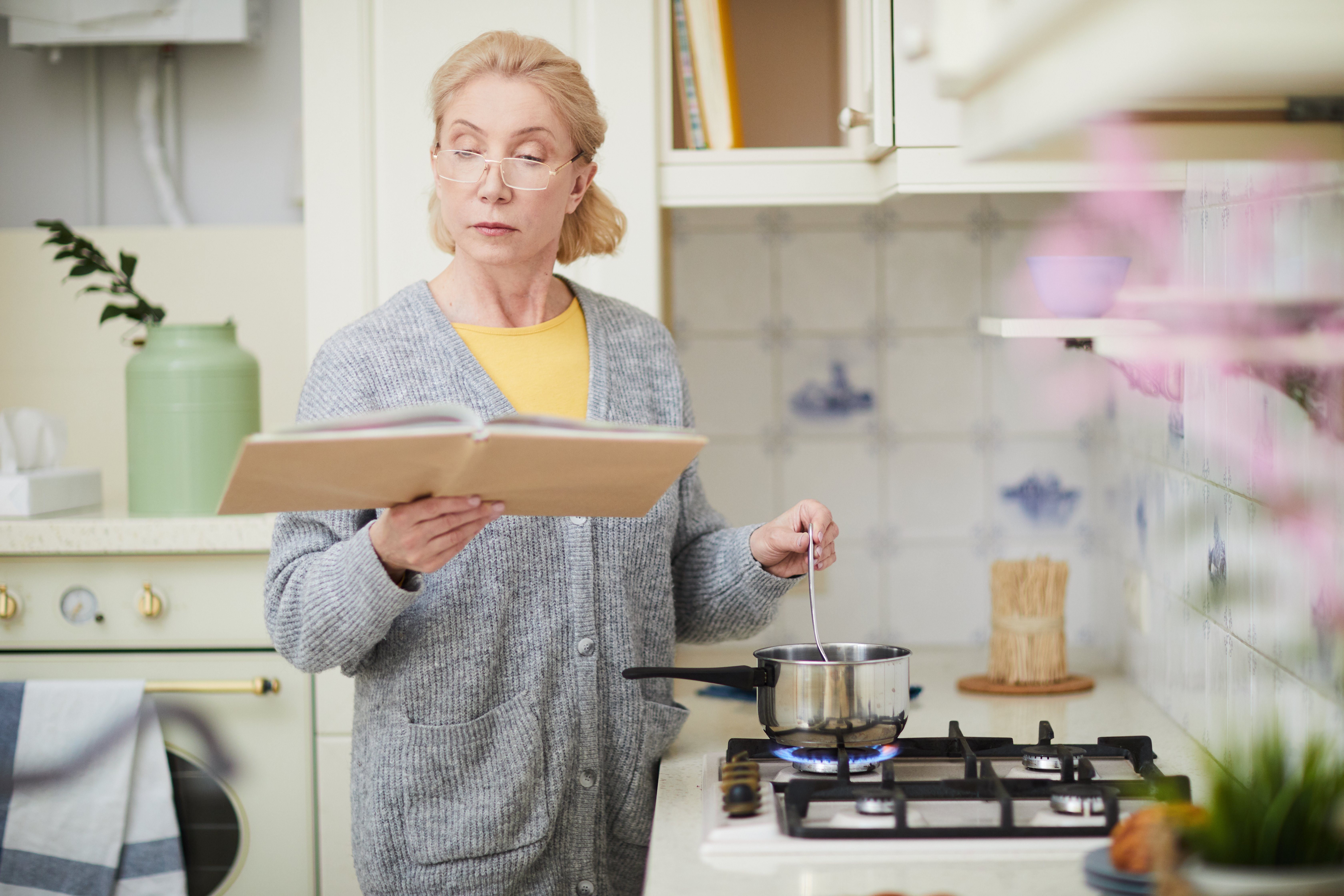 Woman Cooking In Kitchen With Recipe Card Binder